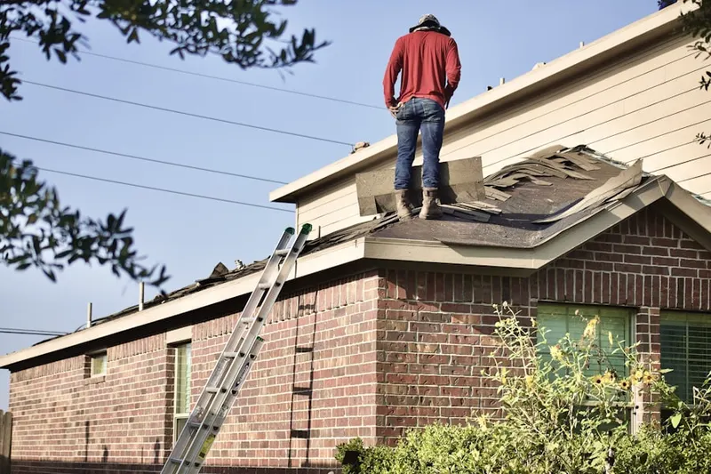 Professional roofer working on a residential roof in Elmont